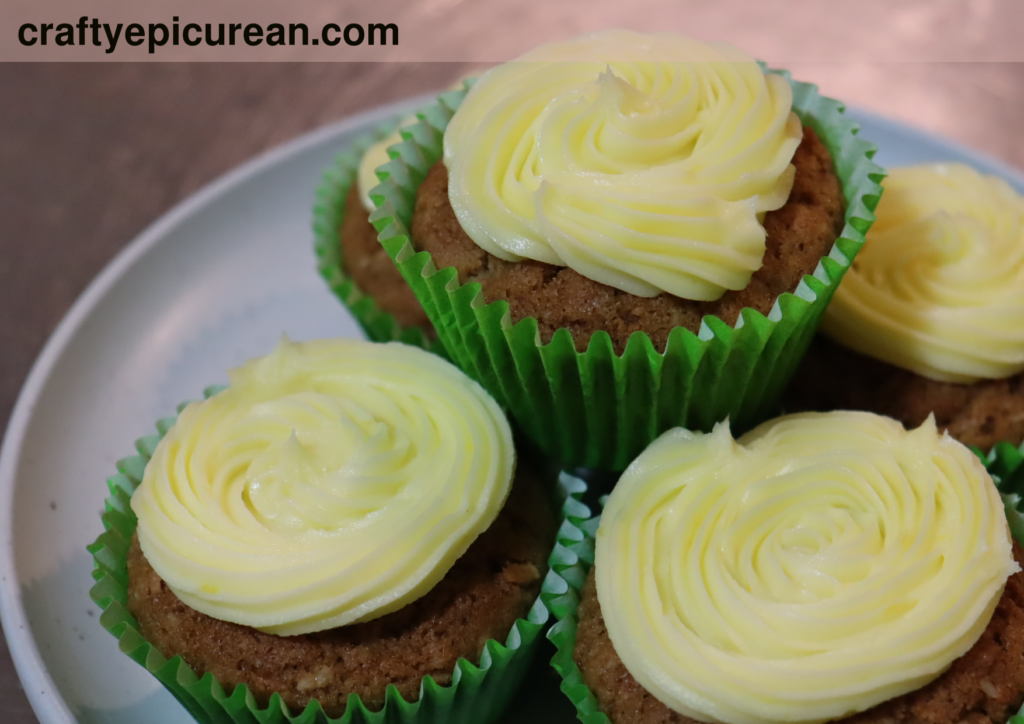 Plate of gluten free carrot cake muffins with piped lemon buttercream frosting